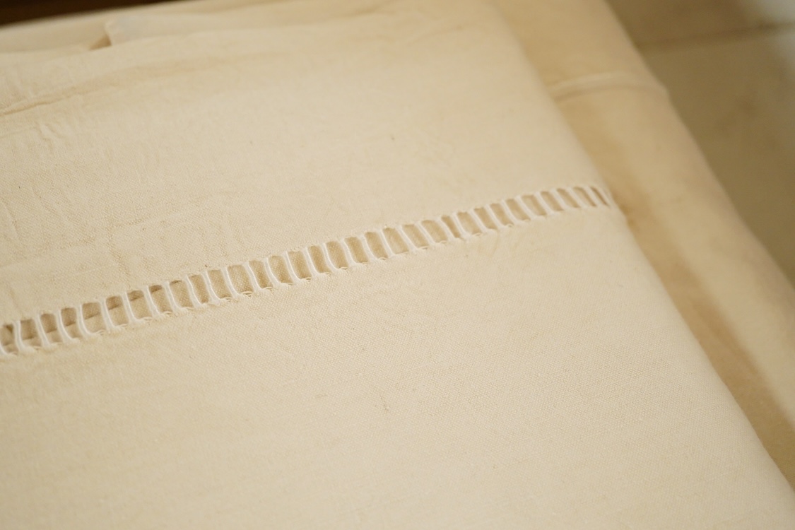 Seven French provincial coarse linen sheets, with a drawn thread bordered large white monogrammed turn backs